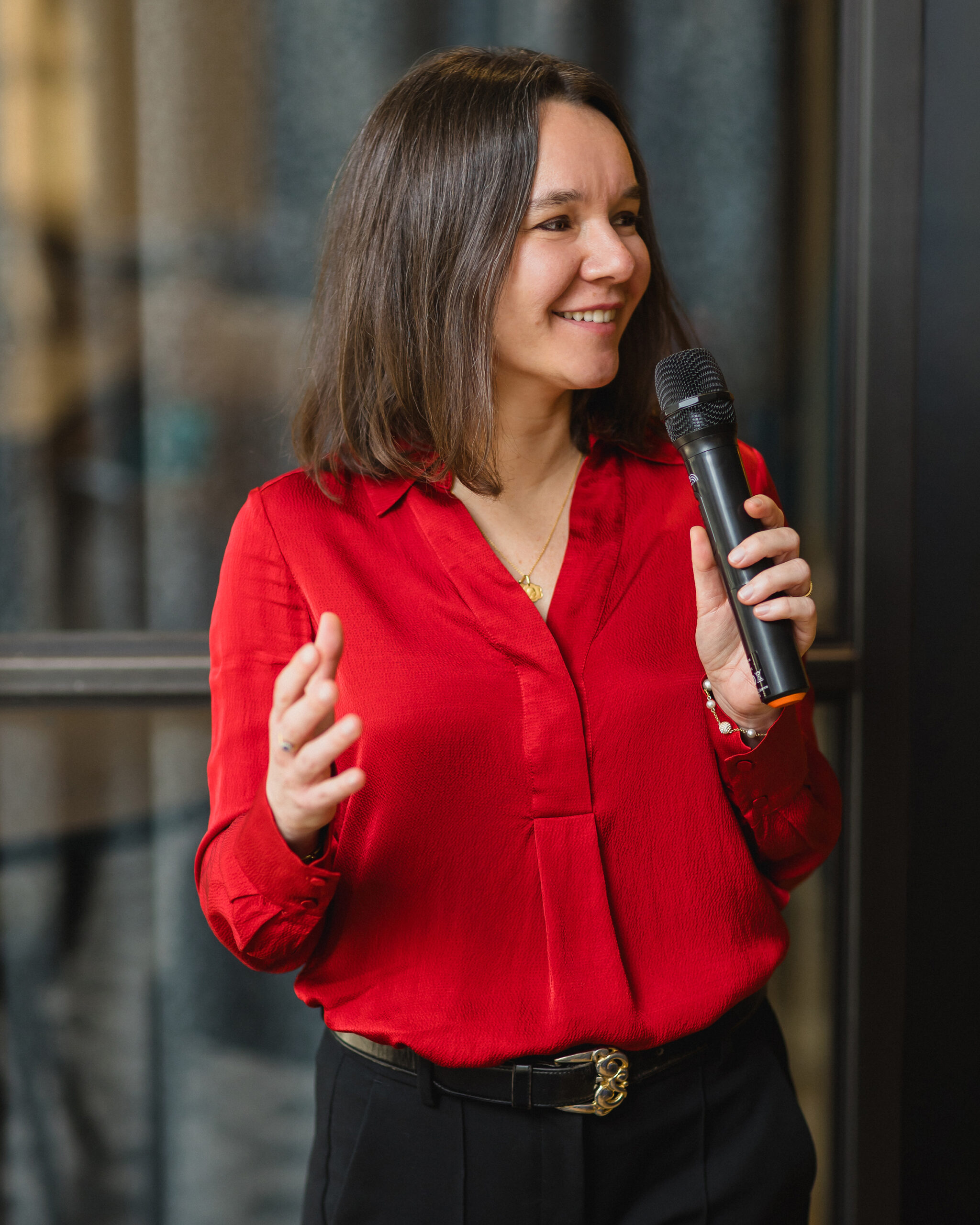 Laurence Galland presenting at a conference, smiling and speaking with open hand gestures